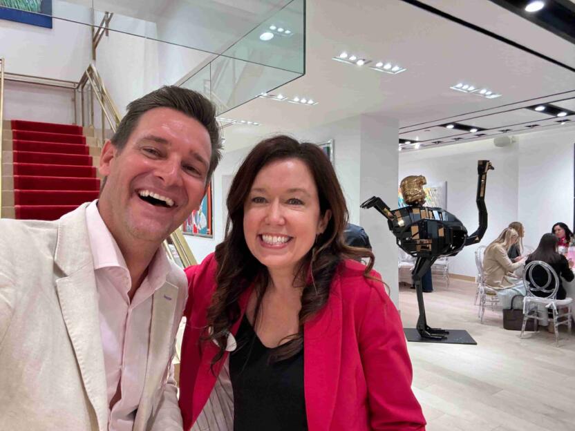 A couple taking a selfie at an event in an art gallery